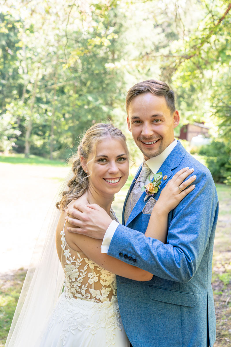 Brautpaar schaut lächelnd in die Kamera