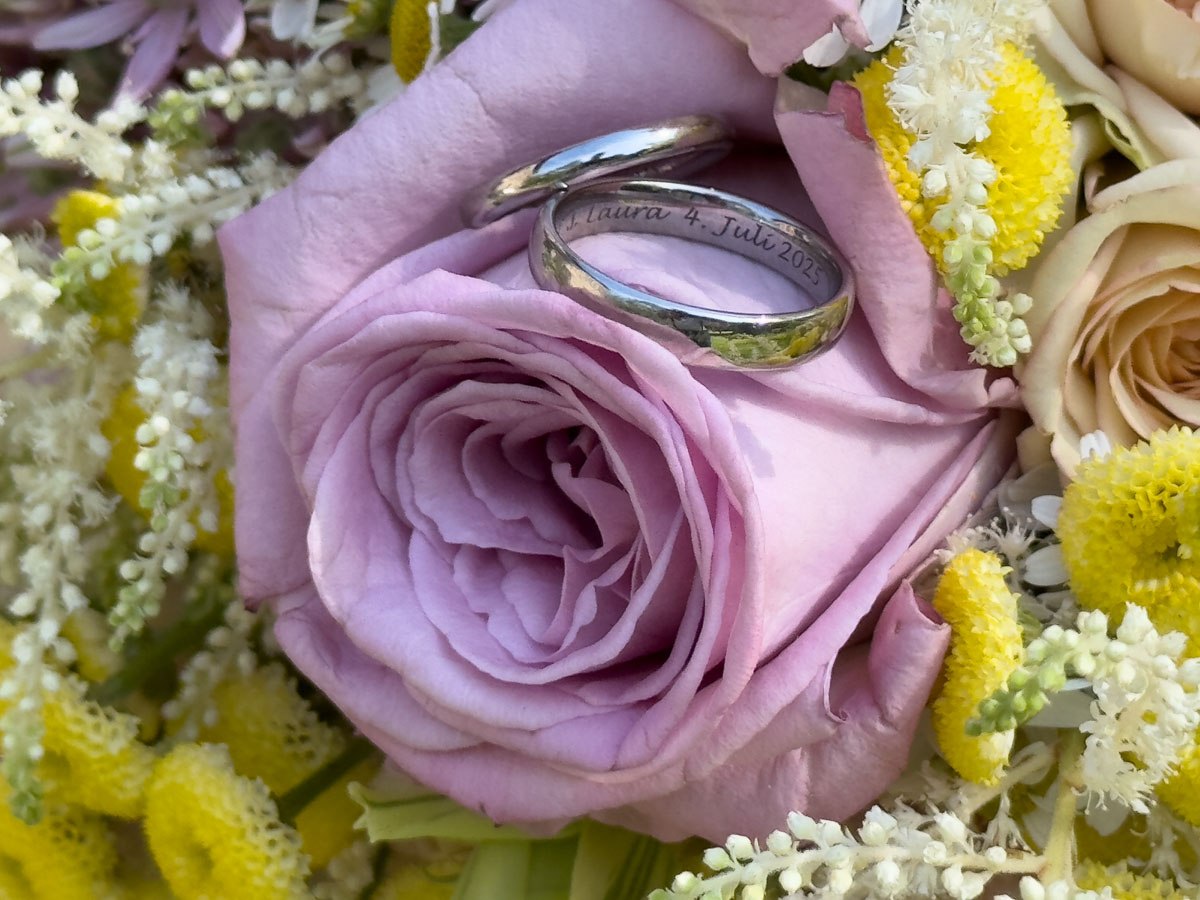 Nahaufnahme der Hochzeitsringe auf dem Brautstrauß
